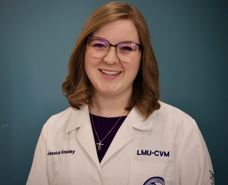 Smiling woman in lab coat with name and LMU-CVM logo.