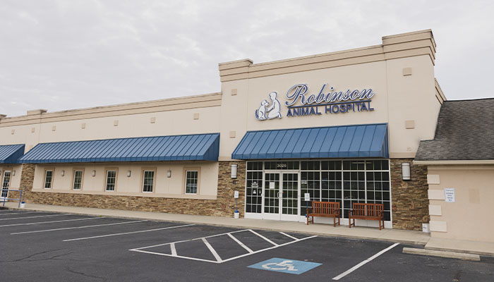 Exterior of Robinson Animal Hospital with blue awnings and parking lot.